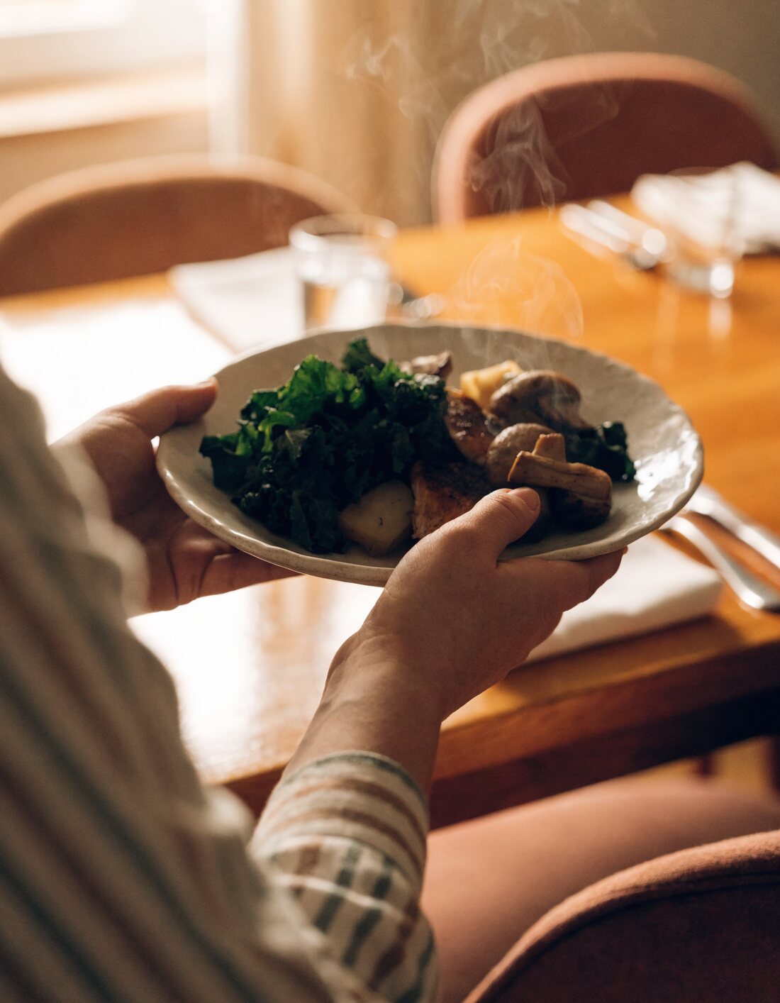 A caregiver serving a fresh home-cooked meal at Sunset Adult Family Home
